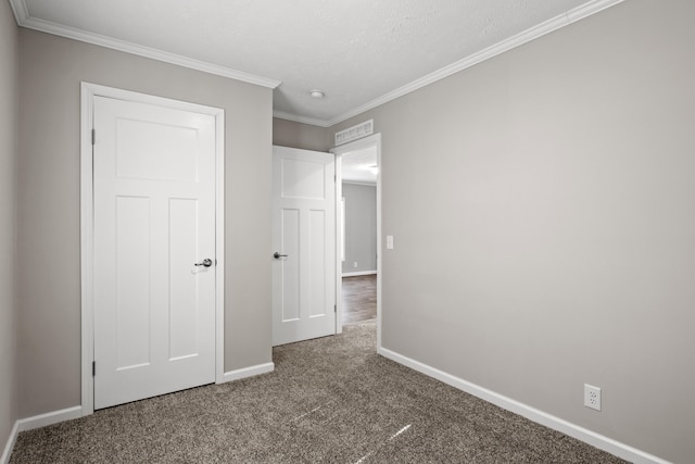 unfurnished bedroom with a textured ceiling, carpet floors, and crown molding