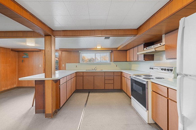 kitchen featuring ventilation hood, kitchen peninsula, white appliances, a breakfast bar area, and light brown cabinetry