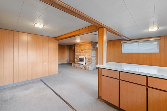 basement featuring light carpet, heating unit, a stone fireplace, and wood walls