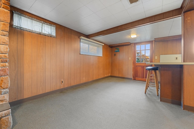 basement featuring wood walls and light carpet