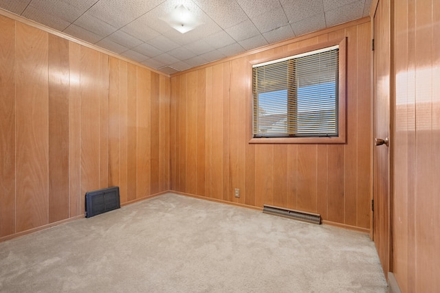 spare room featuring wood walls and light colored carpet