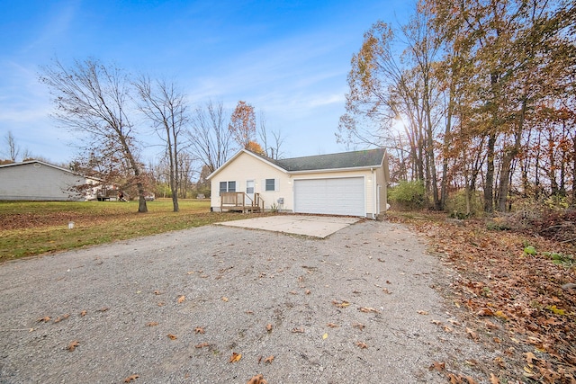 single story home with a garage, a deck, and a front yard