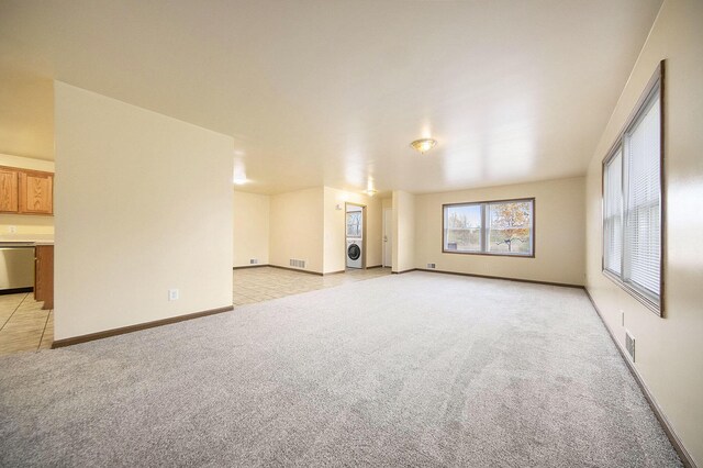 10376 Glencoe Rd, Jerome, MI 49249 - unfurnished living room featuring light colored carpet, washer / dryer, and baseboards