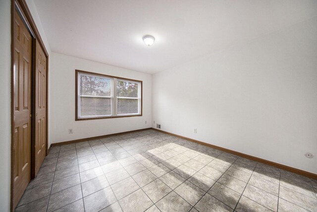 10376 Glencoe Rd, Jerome, MI 49249 - unfurnished bedroom with a closet, light tile patterned floors, and baseboards
