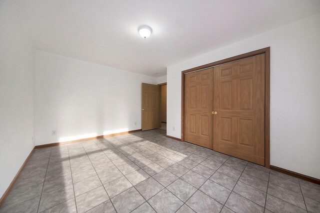 10376 Glencoe Rd, Jerome, MI 49249 - unfurnished bedroom featuring baseboards, light tile patterned floors, and a closet