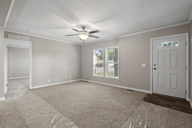 entrance foyer with light carpet, ceiling fan, and ornamental molding