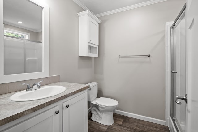 bathroom with hardwood / wood-style floors, vanity, toilet, ornamental molding, and walk in shower