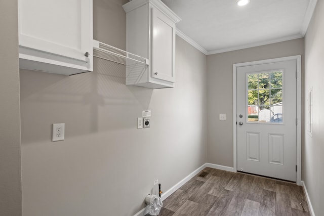 clothes washing area featuring hardwood / wood-style floors, hookup for an electric dryer, cabinets, and crown molding