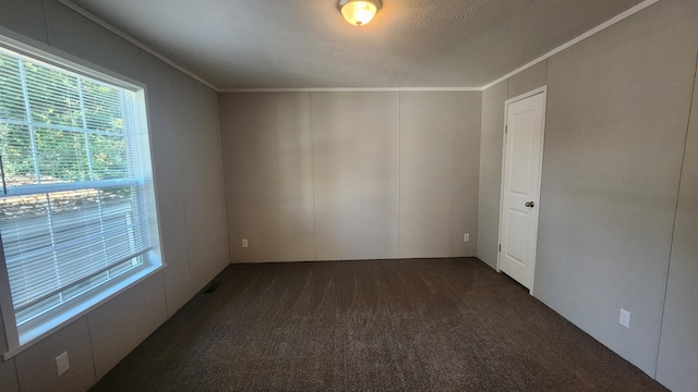 875 W Grand River Ave Unit 35, Williamston, MI 48895 - spare room with dark colored carpet, healthy amount of natural light, crown molding, and a decorative wall