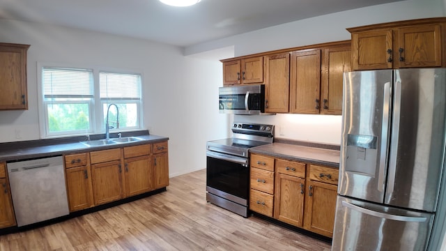 kitchen featuring sink, appliances with stainless steel finishes, and light hardwood / wood-style flooring