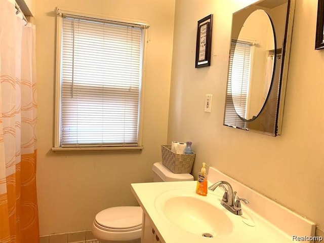 bathroom featuring vanity, a healthy amount of sunlight, and toilet