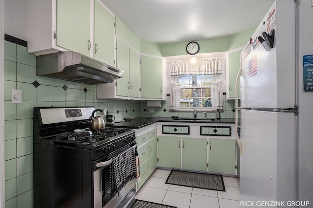 4102 Highgate Rd, Norton Shores, MI 49441 - kitchen featuring tasteful backsplash, stainless steel gas range, freestanding refrigerator, under cabinet range hood, and a sink
