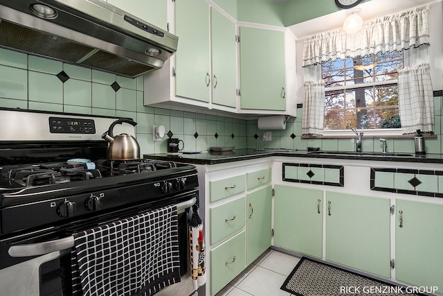 4102 Highgate Rd, Norton Shores, MI 49441 - kitchen featuring stainless steel range with gas cooktop, ventilation hood, a sink, dark countertops, and decorative backsplash