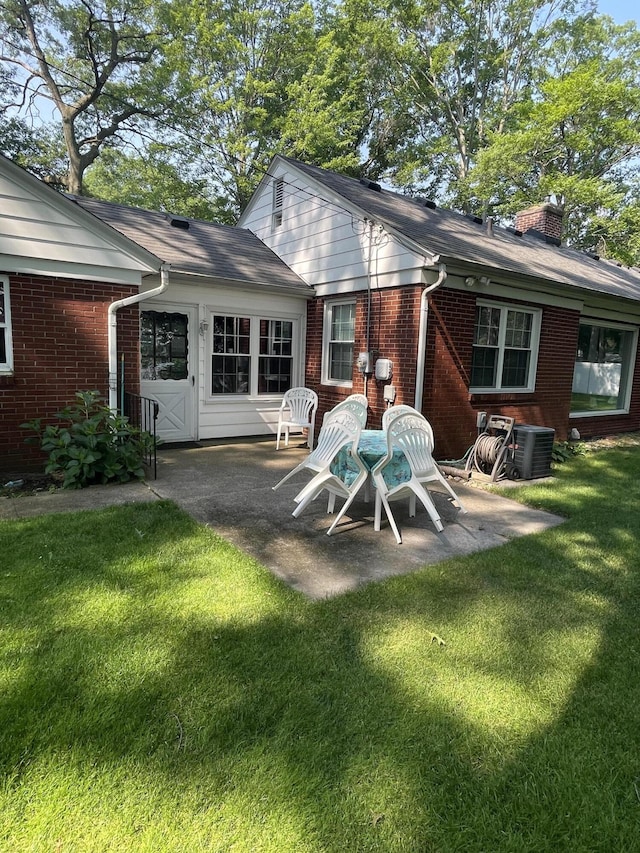 4102 Highgate Rd, Norton Shores, MI 49441 - back of house with brick siding, a yard, a patio, and a chimney