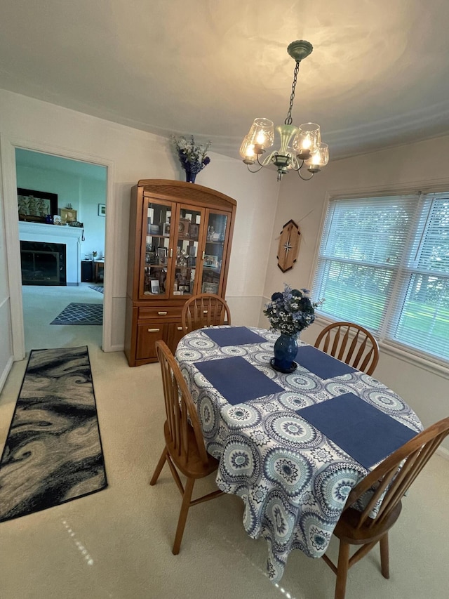 4102 Highgate Rd, Norton Shores, MI 49441 - dining space featuring light colored carpet, an inviting chandelier, and a fireplace