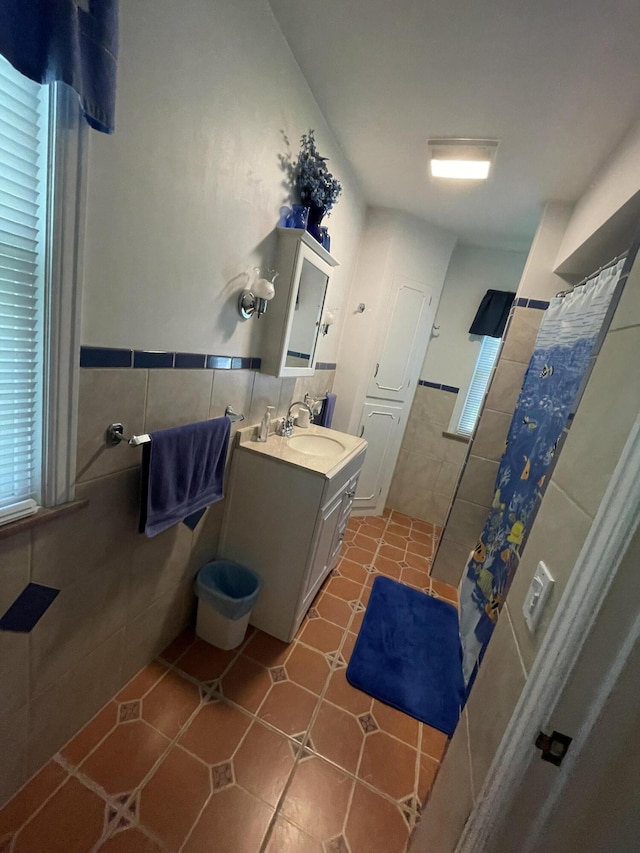 4102 Highgate Rd, Norton Shores, MI 49441 - full bath with vanity, tile patterned flooring, curtained shower, wainscoting, and tile walls