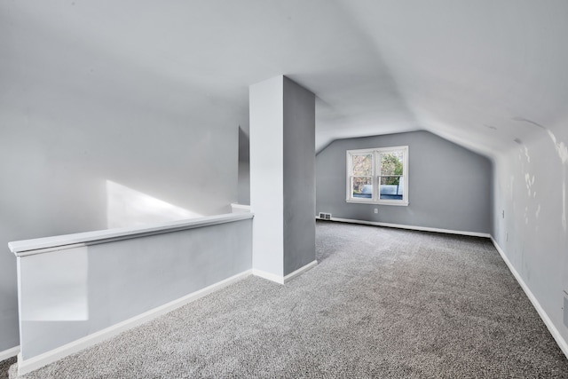 bonus room with carpet flooring and vaulted ceiling