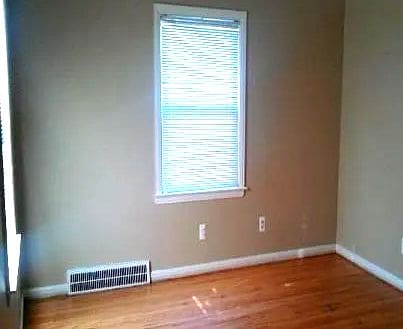 unfurnished room with hardwood / wood-style flooring