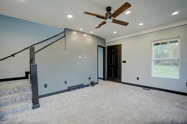 empty room featuring ceiling fan and light colored carpet