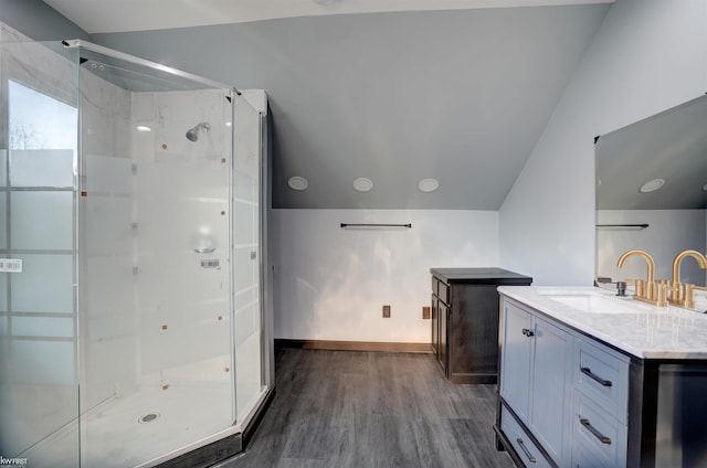 bathroom featuring vanity, hardwood / wood-style flooring, an enclosed shower, and lofted ceiling