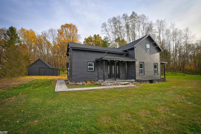 rear view of property with a lawn and an outdoor structure