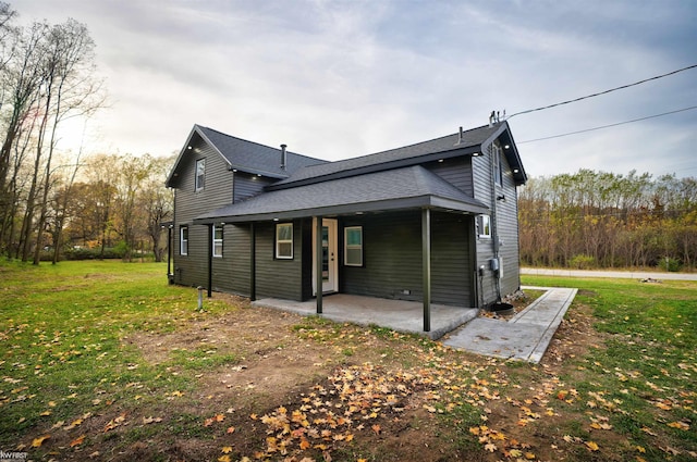 rear view of property with a yard and a patio