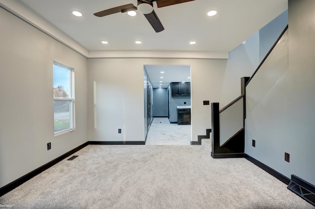 unfurnished living room with ceiling fan and light colored carpet