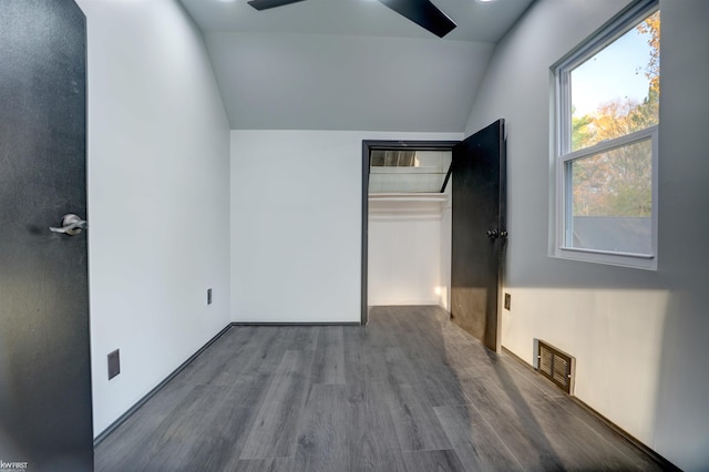 unfurnished bedroom featuring ceiling fan, a closet, wood-type flooring, and lofted ceiling