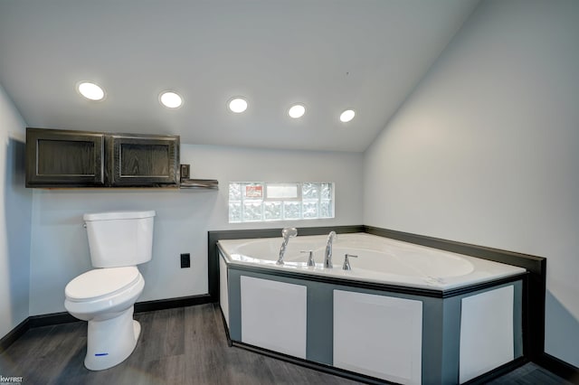 bathroom with wood-type flooring, lofted ceiling, toilet, and a tub