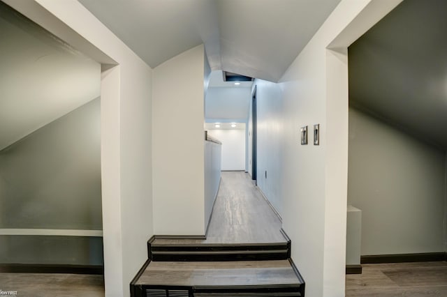 hall with wood-type flooring and lofted ceiling