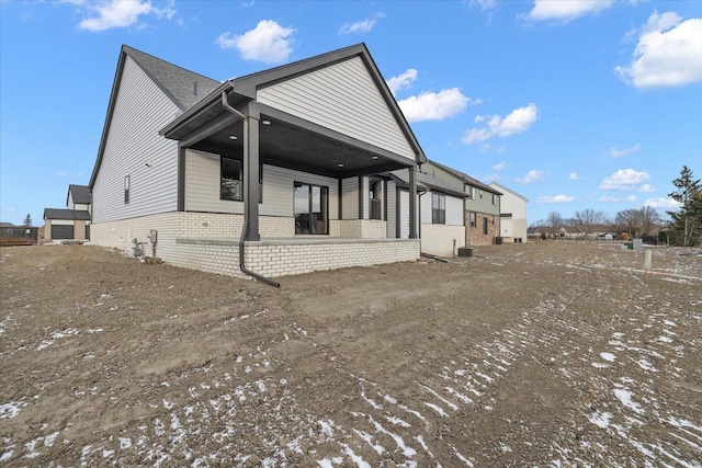 snow covered property featuring cooling unit and covered porch