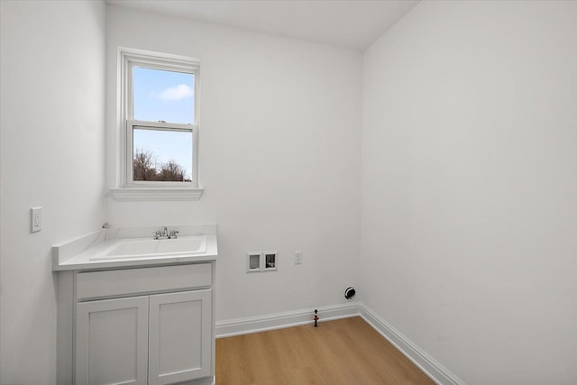 laundry room with cabinets, hookup for a washing machine, gas dryer hookup, sink, and light hardwood / wood-style floors