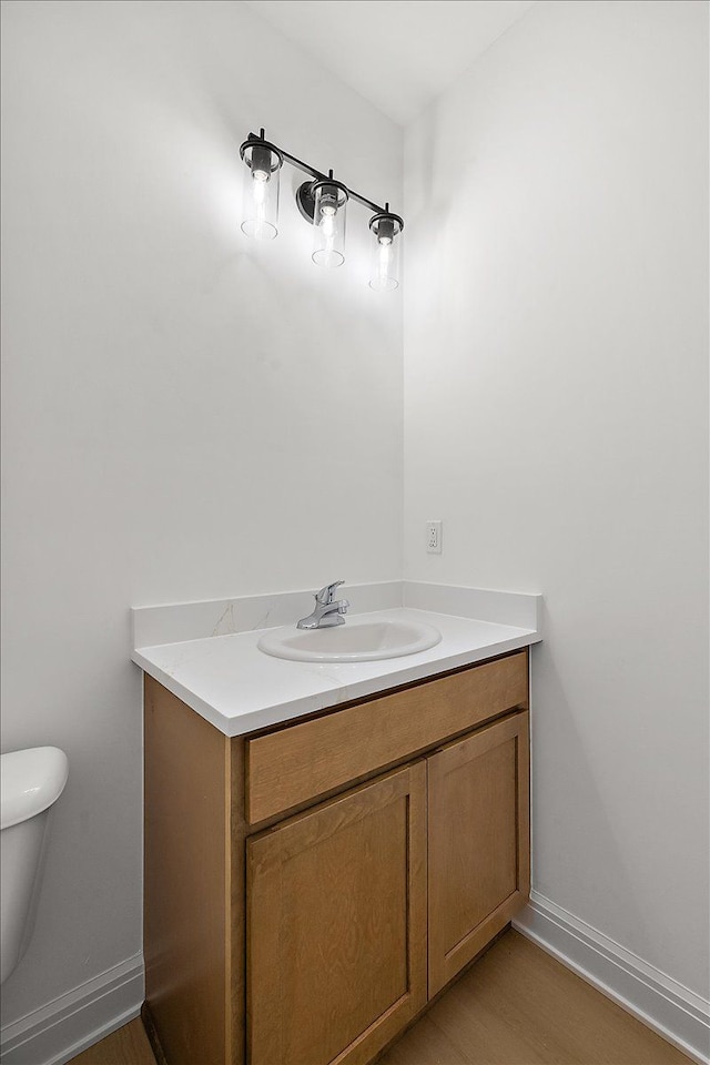 bathroom with vanity, hardwood / wood-style flooring, and toilet