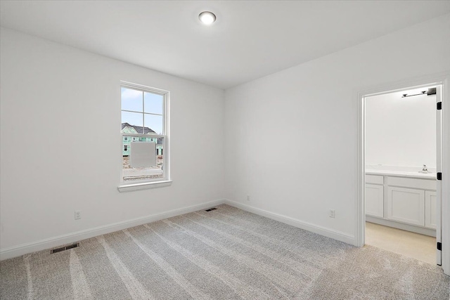 empty room with light colored carpet and sink