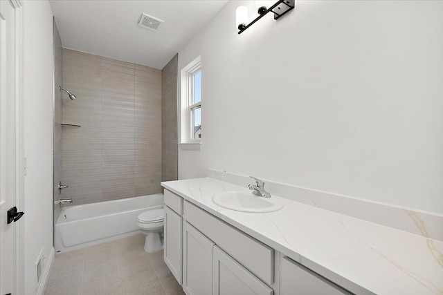 full bathroom featuring tiled shower / bath, tile patterned floors, vanity, and toilet