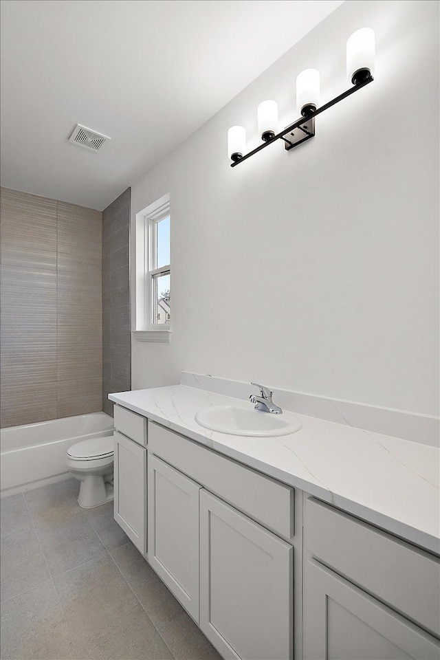 full bathroom with tile patterned flooring, vanity, toilet, and tiled shower / bath