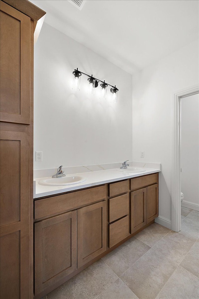 bathroom with tile patterned flooring, vanity, and toilet