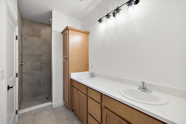 bathroom featuring tile patterned flooring, vanity, and tiled shower