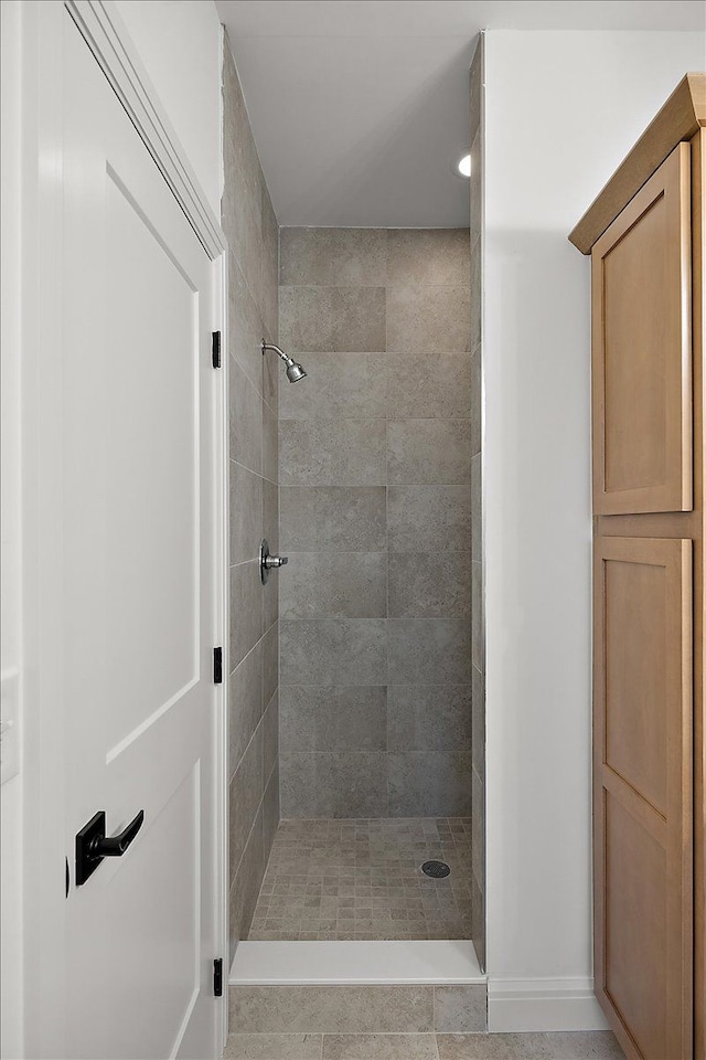 bathroom with tile patterned floors and tiled shower