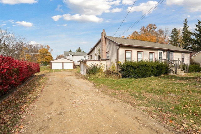 view of front of property featuring a garage and an outdoor structure