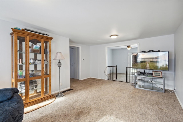 carpeted living room with ceiling fan