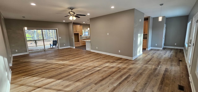 unfurnished living room with wood-type flooring and ceiling fan