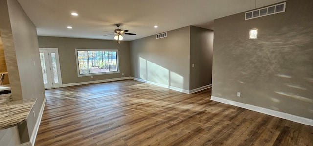 unfurnished living room with ceiling fan and dark hardwood / wood-style flooring