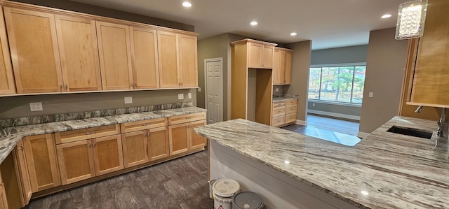 kitchen featuring pendant lighting, sink, light stone countertops, dark wood-type flooring, and light brown cabinets