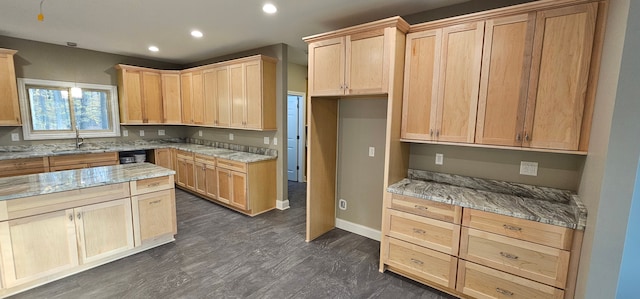 kitchen featuring dark wood-type flooring, light stone countertops, sink, and light brown cabinets