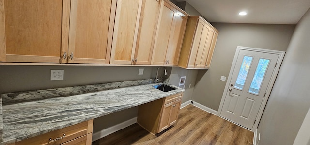 laundry room with cabinets, hookup for a washing machine, sink, and light hardwood / wood-style flooring