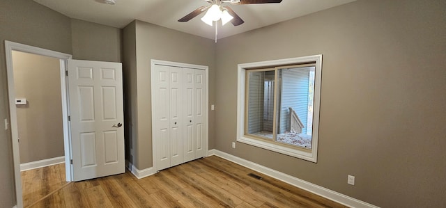 unfurnished bedroom with light hardwood / wood-style floors, a closet, and ceiling fan