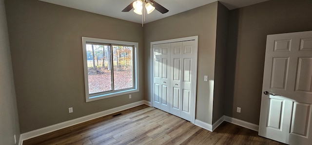 unfurnished bedroom featuring ceiling fan, a closet, and light wood-type flooring