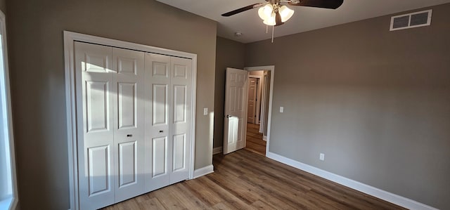 unfurnished bedroom with hardwood / wood-style flooring, a closet, and ceiling fan