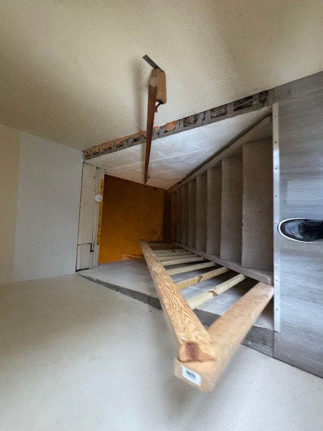 stairs featuring concrete flooring